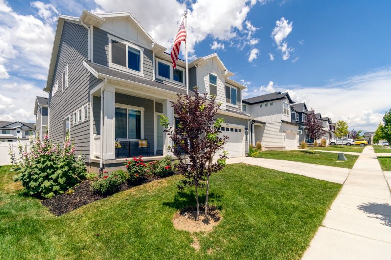 Modern suburban house with garden, featuring beautiful architecture and an American flag.