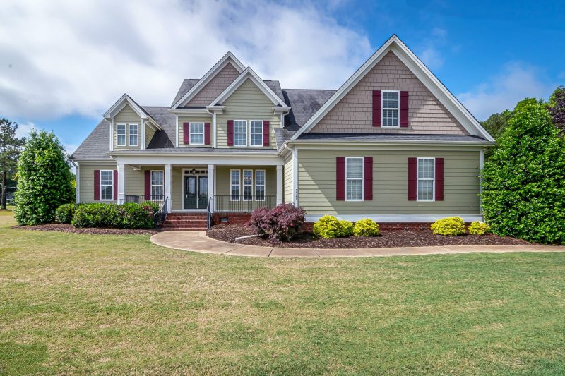 Beautiful two-story suburban house with a manicured lawn and a welcoming front porch.