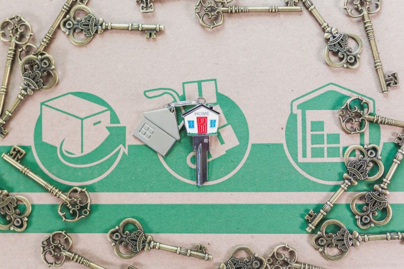 A collection of vintage keys alongside a modern house key, representing real estate investment.