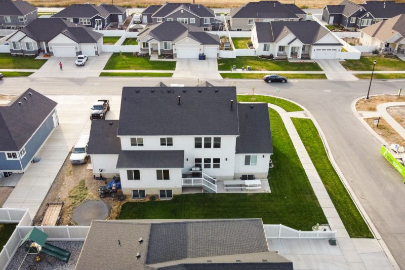 Aerial view of a suburban neighborhood in Spanish Fork, Utah, featuring modern homes and lush green lawns.