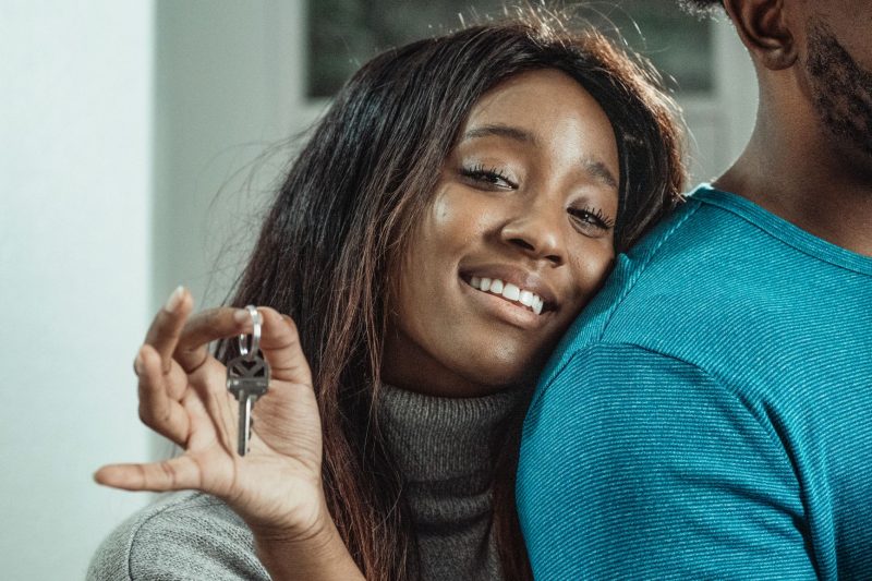 Joyful couple celebrating their new home purchase, holding a set of house keys together.